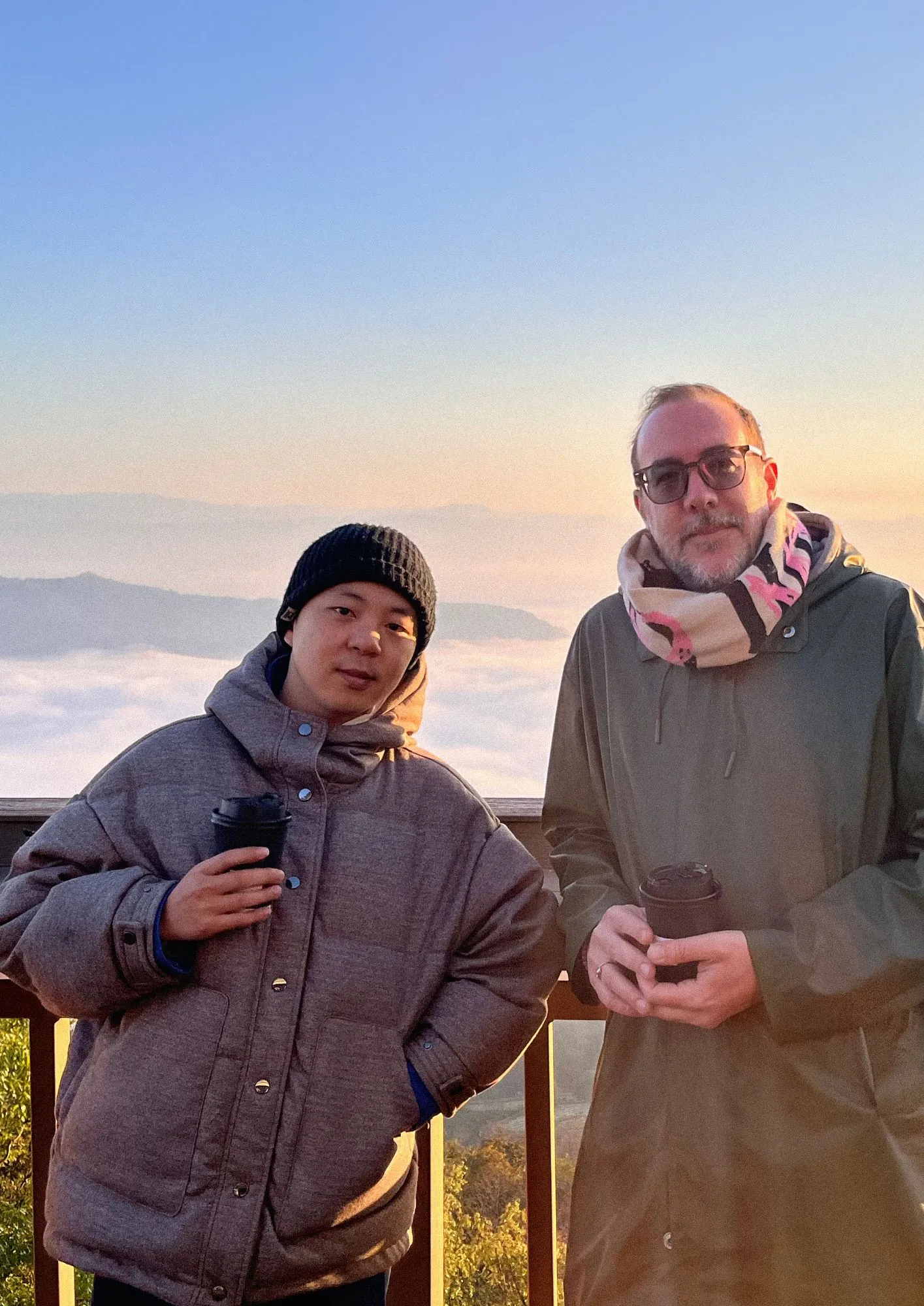 Jixuan et Antoine, fondateurs de Yunma, au lever du jour sur une crête du Yunnan au-dessus d’une mer de nuages, un café à la main