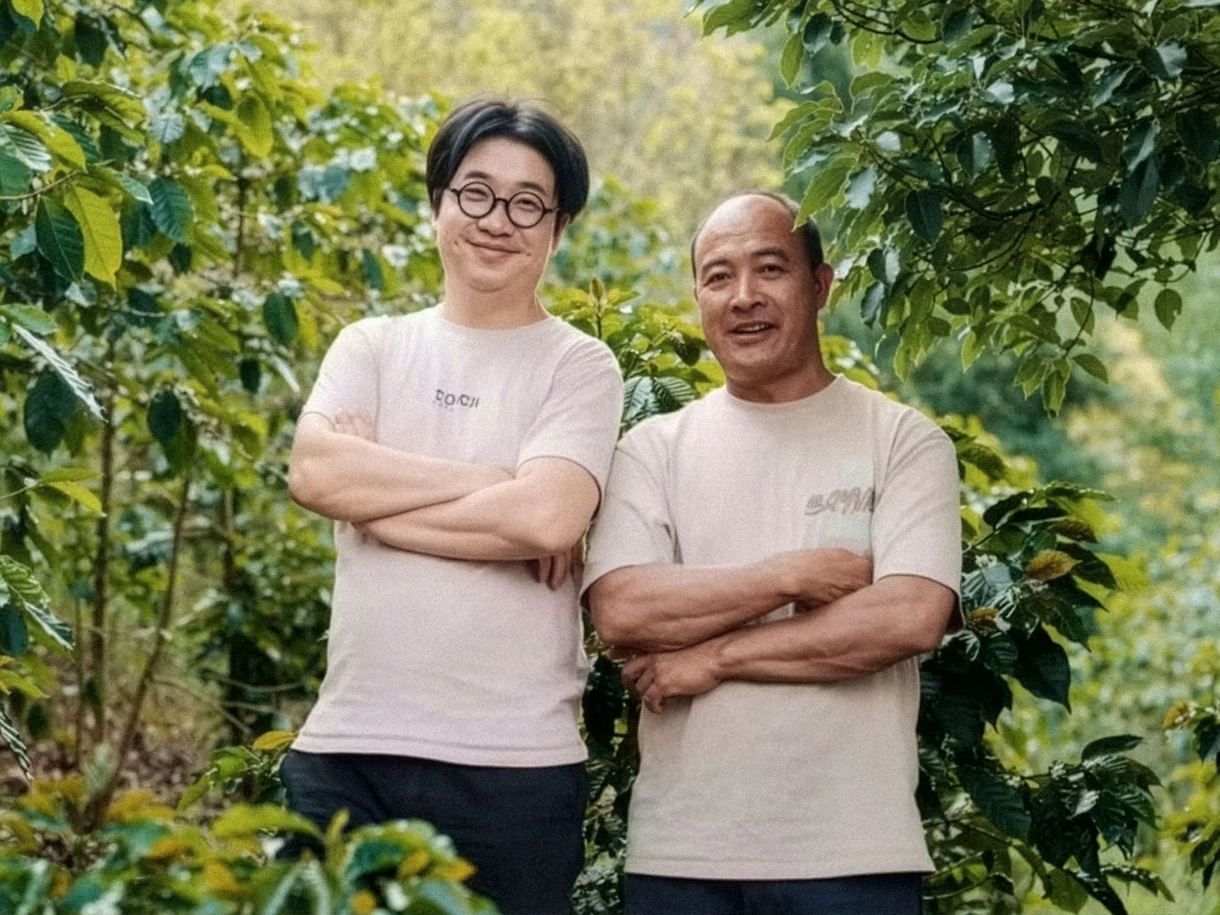 Portrait des deux producteurs de Torch Estate devant leurs caféiers, à Pu’er